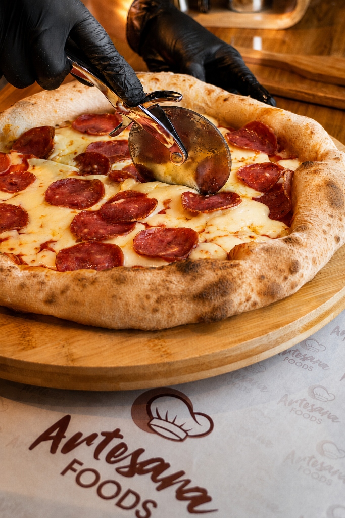 Pizza pepperoni artesanal cortada con cortador — Artesana Foods